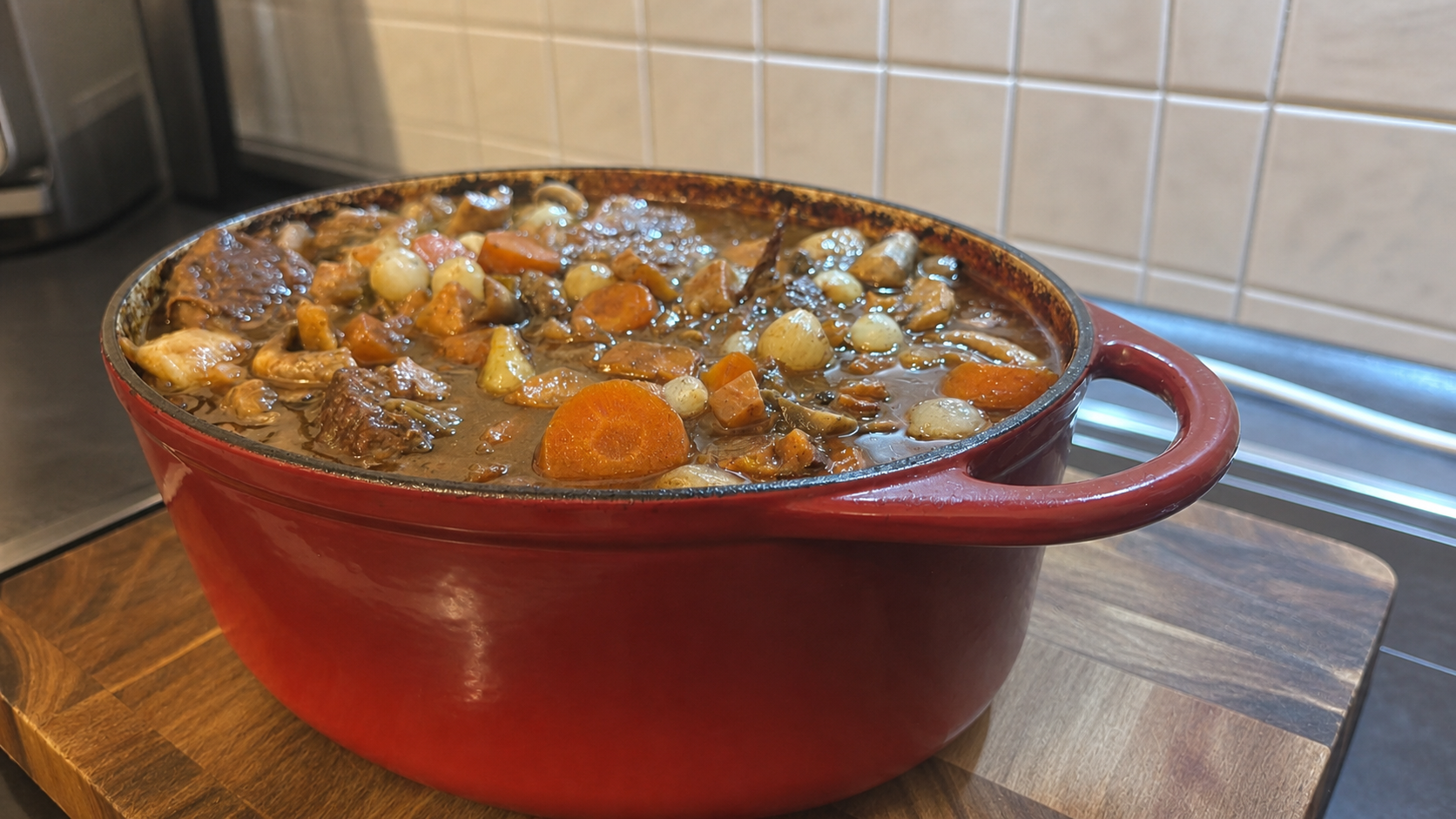 Fertiges Boeuf Bourguignon mit Rindfleisch, Karotten, Champignons und Perlzwiebeln im roten Bräter